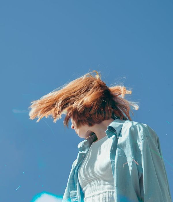 Woman feeling energetic and vibrant in a bright, modern space.